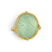 A gold ring featuring a prehnite with a fairy design carved in it, shown against a white background.