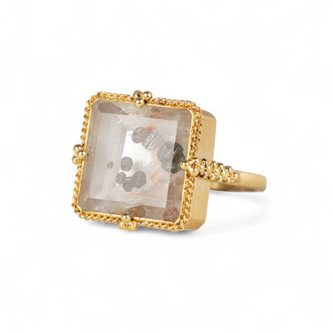 Handmade 18k gold ring with a large quartz on a white background.