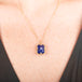 Handmade gold necklace with a blue tanzanite gemstone pendant on a person