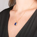 Handmade gold necklace with a blue tanzanite gemstone pendant on a person