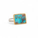 Turquoise ring with gold bezel and silver band on white background
