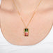 Watermelon tourmaline gemstone necklace with a gold setting worn on a person