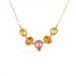A gold necklace featuring a row of sapphire gemstones in different shapes and colors, shown against a white background.
