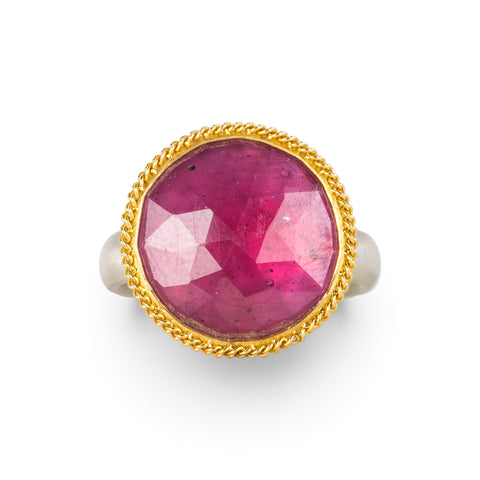 Gold and silver ring featuring a bright pink sapphire gemstone, shown against a white background.