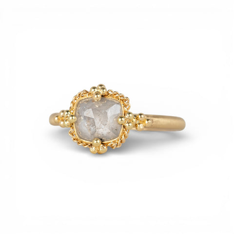 Gold ring with a silver diamond on a white background