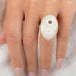 An oval ring featuring a solar quartz stone set in a textured gold bezel with a sterling silver band, worn on a person's finger.