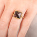 A model wears an 18k yellow gold and super 7 gemstone ring.