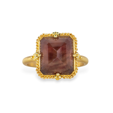 A gold ring featuring an Oregon Sunstone gemstone in a 18k gold bezel setting, shown against a plain white background.