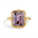 Gold ring with a purple Super 7 gemstone on a white background