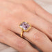 Gold ring with a purple Super 7 gemstone on a hand