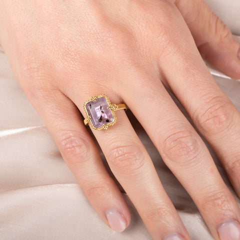 Gold ring with a purple Super 7 gemstone on a hand