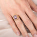 Gold ring with a purple Super 7 gemstone on a hand