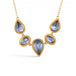 A gold necklace featuring five tanzanite gemstones in textured gold bezels, displayed on a clean white background.