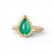 Gold ring with a teardrop-shaped emerald gemstone on a white background