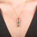Handmade gold necklace with a watermelon tourmaline gemstone pendant on a person