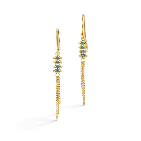 Gold earrings featuring rows of small blue diamonds and tassels made of gold chains streaming below them.