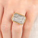 Close up of a person wearing a handmade fine jewelry tourmalated quartz ring in 18k gold and sterling silver