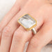 Close up of a person wearing a handmade fine jewelry tourmalated quartz ring in 18k gold and sterling silver