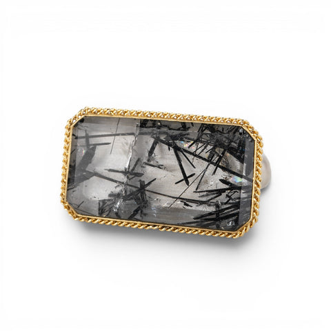 A rectangular ring featuring a tourmalated quartz crystal with visible needle-like inclusions, set in a gold bezel.