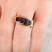 Close up of hand wearing a watermelon tourmaline ring with gold bezel and silver band