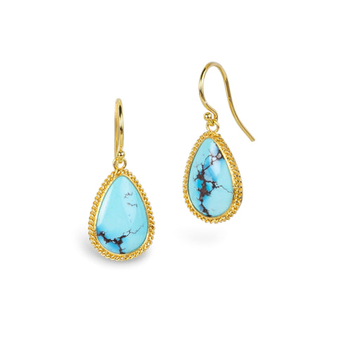 A pair of gold drop earrings featuring teardrop-shaped turquoise stones with natural dark veining, set in textured gold bezels, shown on a plain white background.