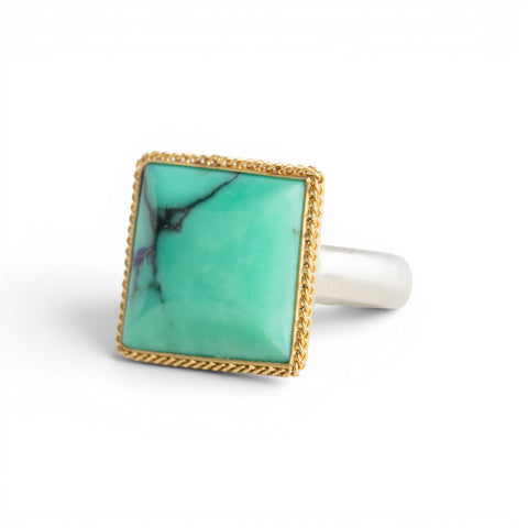 A gold and silver ring featuring a Variscite stone against a white backdrop.