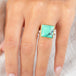 A gold and silver ring featuring a Variscite stone worn on a finger.