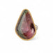Ring with a teardrop-shaped watermelon tourmaline gemstone in a gold bezel with a sterling silver band on a white background