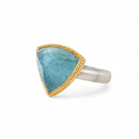Aquamarine stone ring with gold setting and silver band on a white background