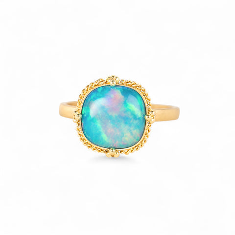 Gold ring with an Ethiopian opal stone on a white background