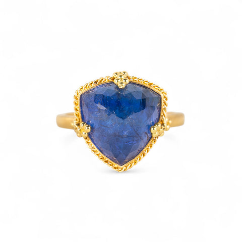 Gold ring with a tanzanite gemstone on a white background