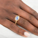 Gold ring with a blue dumortierite stone on a person's finger
