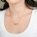 Boulder opal necklace with gold chain on a person