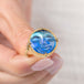Gold ring with a carved face moonstone gemstone held in hand