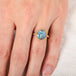 Gold ring with a carved moonstone on a person's finger