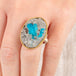 Close up of a handmade fine jewelry ring with a cavansite crystal stone set in an 18k gold bezel with a sterling silver band