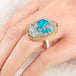 A close up of a person wearing a handmade fine jewelry ring with a cavansite crystal stone set in an 18k gold bezel with a sterling silver band