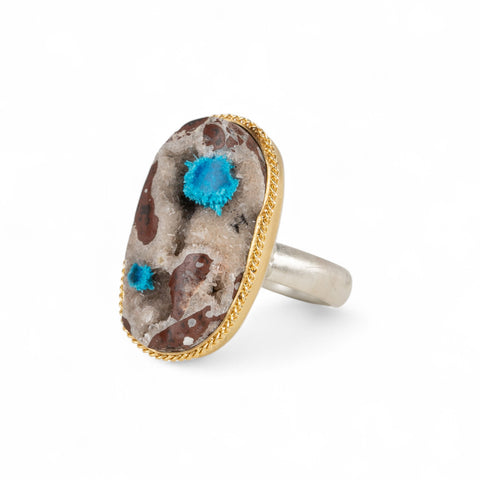 Handcrafted ring with a cavansite quartz gemstone, 18k gold bezel and sterling silver band on a white background