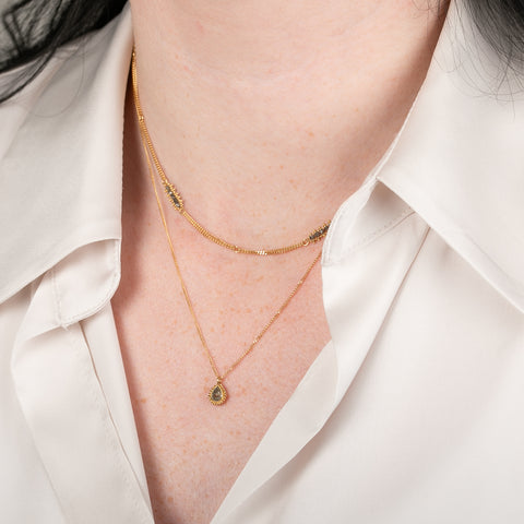 Gold necklace with a natural-colored diamond on a person