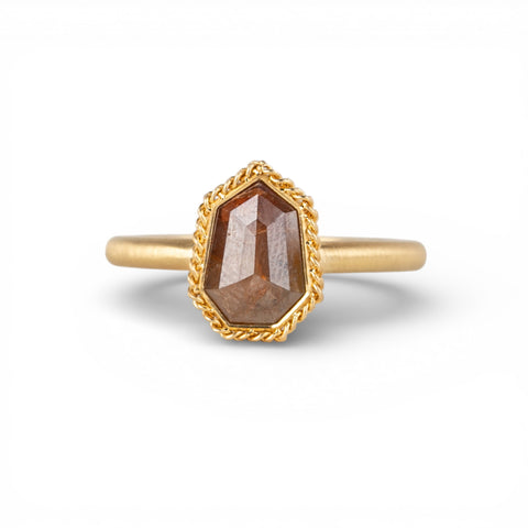 Gold ring with a brown diamond on a white background