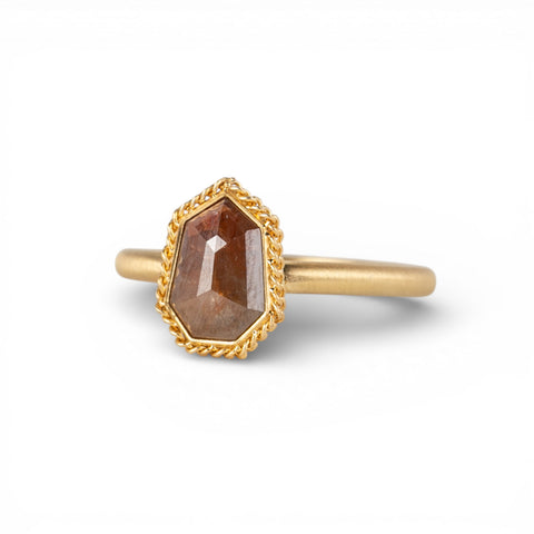 Gold ring with a brown diamond on a white background