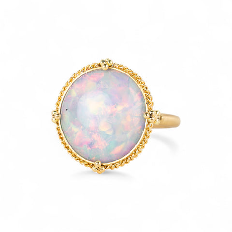 Gold ring with an opal stone on a white background