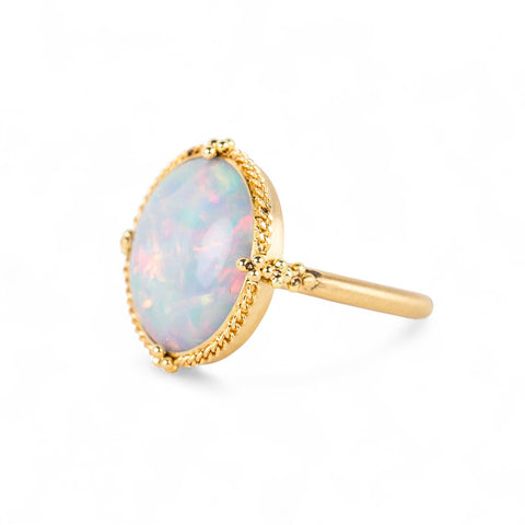Gold ring with an opal stone on a white background