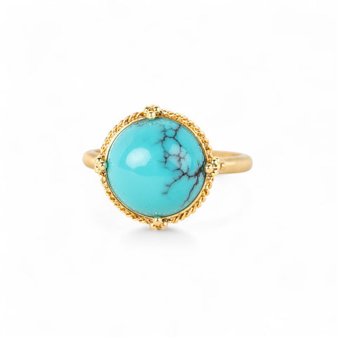 Gold ring with a turquoise stone on a white background