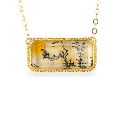 Gold necklace with a rectangular pendant featuring a dendritic quartz with a nature design on a white background