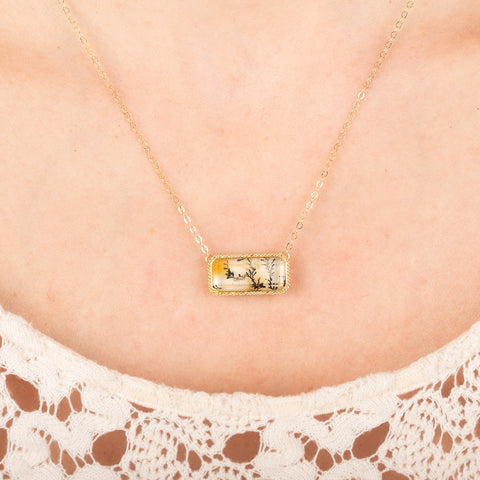dendritic quartz gold necklace worn on a person
