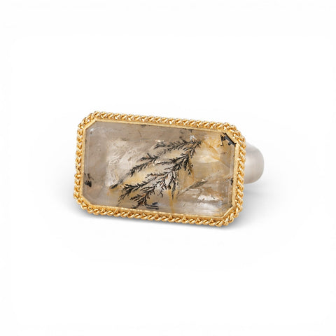 Ring with gold frame and sterling silver band featuring a dendritic quartz stone on a white background