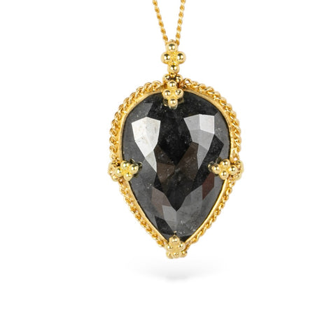 Gold necklace with a black diamond teardrop-shaped pendant on a white background