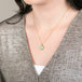 Gold necklace with an Ethiopian opal gemstone pendant on a person