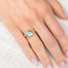 Gold ring with a blue aquamarine gemstone on a hand